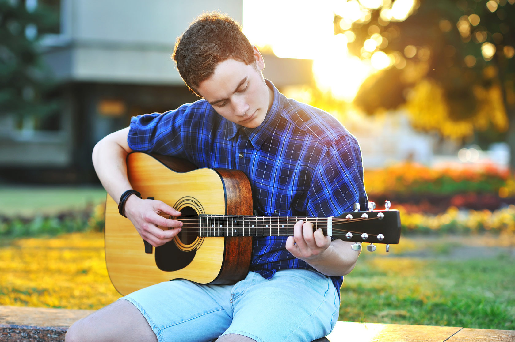 Игра на гитаре время. Парень с гитарой. Игра на гитаре. Подросток с гитарой. Человек сидит с гитарой.